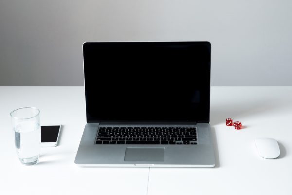 Closeup image of a laptop with blank screen on the table in office over gray background