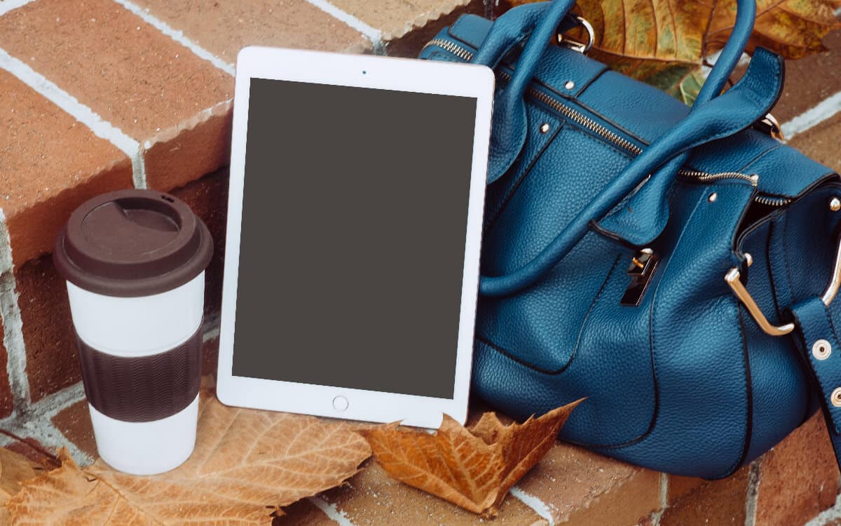 Tablet in front of bag and leaves